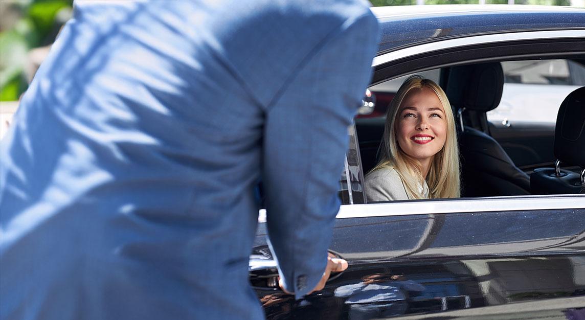 Hourly chauffeur — driver greeting passenger in car
